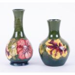 William Moorcroft, two similar vases on green ground, decorated with flowers, each with paper