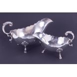 A pair of Edwardian silver sauce boats each with scroll acanthus handle on 'hoof' feet, the