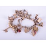 A 9ct gold charm bracelet with heart padlock with 19 charms (some not hallmarked & not