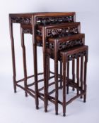 A nest of four Chinese carved hardwood side tables.