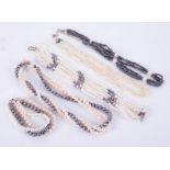 A three row strung set of black and white fresh water pearls, white and black set and others.