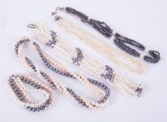 A three row strung set of black and white fresh water pearls, white and black set and others.