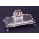 An Edwardian silver inkwell and stand, the oblong tray with Chippendale style edge on scrolled