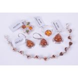 A collection of five pieces of silver amber set jewellery to include a pendant set with