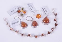 A collection of five pieces of silver amber set jewellery to include a pendant set with