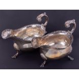 Two similar Georgian silver sauce boats, hallmarked London, each with acanthus scroll handle,