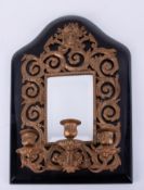 A black wood and gilt wall mirror with three candle sconces.