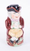 An antique Toby jug with hat (cup) sat with crossed legs, mark No 8 on base, damaged, height 25cm.