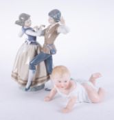 Lladro, a dancing couple, 29cm, finger damaged and a piano bisque baby figure (af).