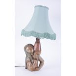 A Lladro lady lamp holding water jug with shade.