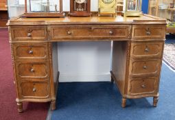 An early 20th Century kneehole desk fitted with an arrangement of nine drawers, width 118cm.