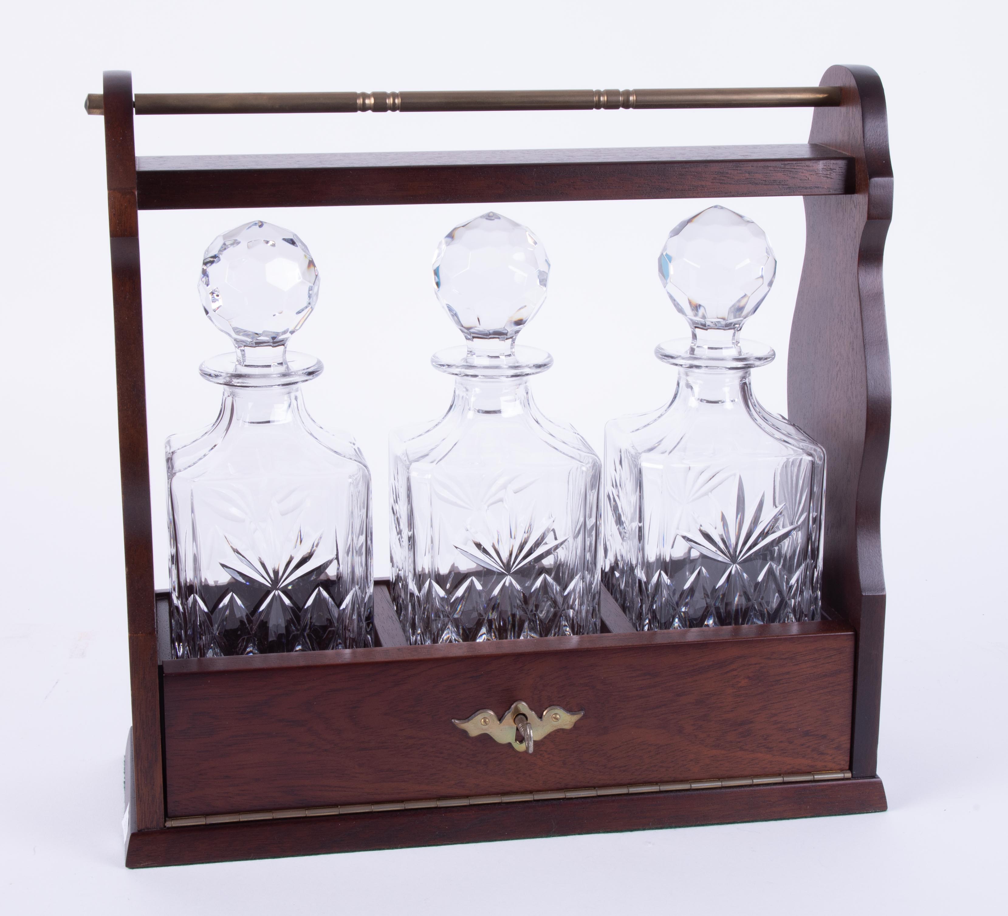 A modern mahogany three glass bottle tantalus, with key.