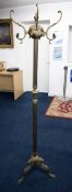 An ornate brass coat stand on tripod base, 167cm height.