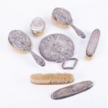 Various dressing table wares including ornate and embossed brushes in silver and a matching circular