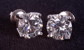 A pair of 18ct white gold four claw solitaire stud earrings set round brilliant cut diamonds,