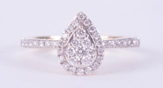 An 18ct yellow gold cluster style ring set in a pear shape set with round brilliant cut Canadian