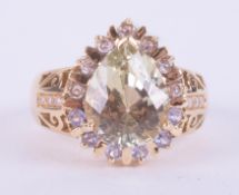 An 18ct yellow gold ornate style ring set with a central pear cut green/yellow tone gemstone