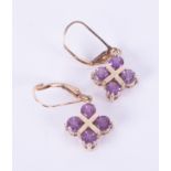 A pair of 9ct yellow gold earrings set with round cut amethysts in a cross style setting, with