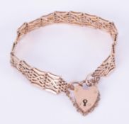 A 9ct rose gold fancy link gate bracelet with a heart padlock and safety chain, 15.19gm.