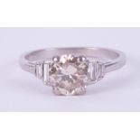 An Art Deco platinum ring set with a central round cut diamond, approx. 1.37 carats, with two