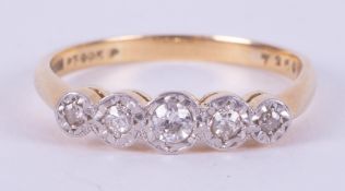 An 18ct yellow gold & platinum five stone ring set with five small round cut diamonds in an illusion