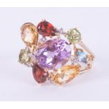 A 9ct yellow gold ring set with a mixture of oval cut, pear shaped and round cut amethyst,