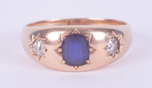 A 15ct yellow gold ring set with a central oval cut sapphire and a round cut diamond to each side in