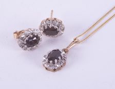 A set comprising of a 9ct yellow & white gold cluster pendant set with a central oval cut dark