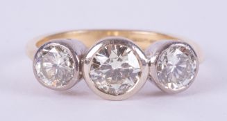 An 18ct yellow & white gold ring set with three round brilliant cut diamonds, total weight approx.