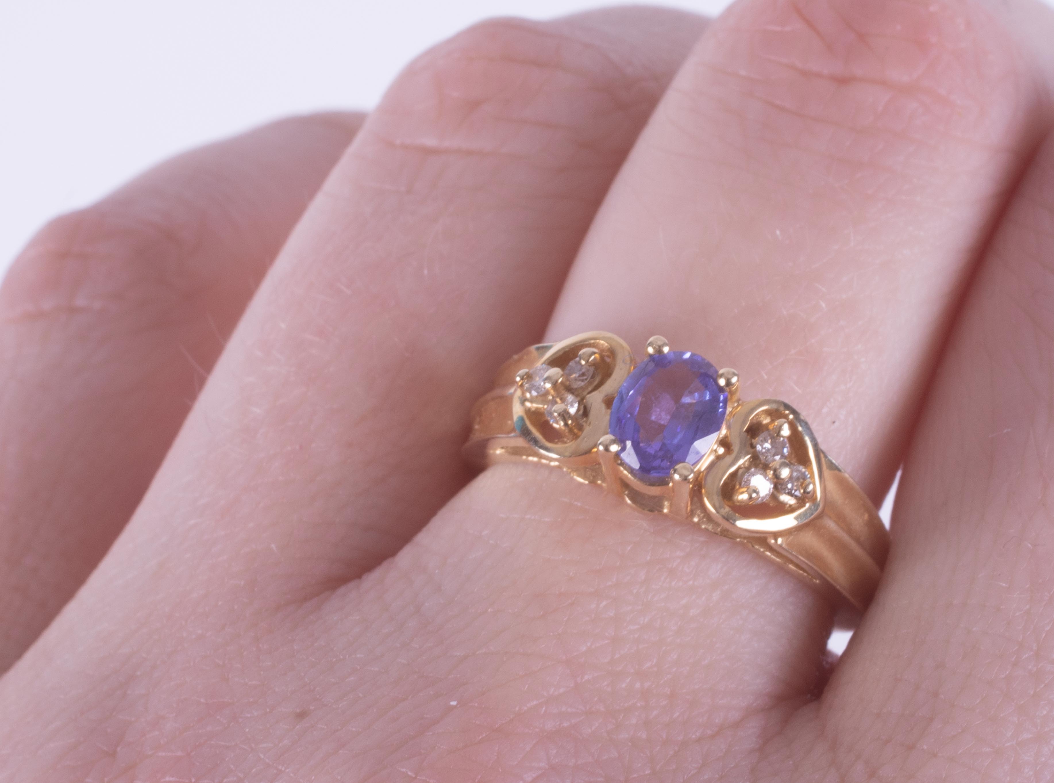 A 14k yellow gold ring set with a central oval cut tanzanite and a trefoil of diamonds to each - Image 2 of 2