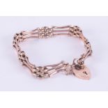 A 9ct rose gold fancy link gate bracelet with a heart padlock & safety chain, 11.74gm,