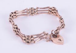 A 9ct rose gold fancy link gate bracelet with a heart padlock & safety chain, 11.74gm,