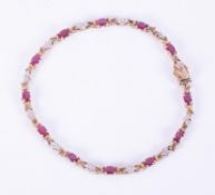 A 9ct yellow gold bracelet set with twelve oval cut rubies, total weight of rubies approximately 2.