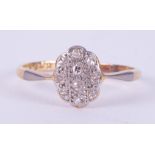 An 18ct yellow gold & platinum ring set with tiny round cut diamonds in an oval illusion style