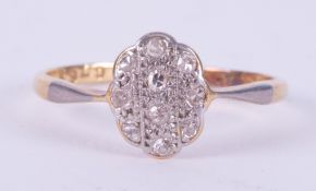 An 18ct yellow gold & platinum ring set with tiny round cut diamonds in an oval illusion style