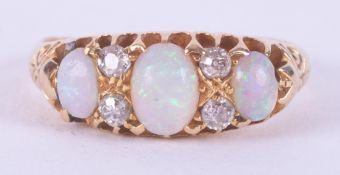 An 18ct yellow gold antique ring set with three oval cabochon cut opals interspaced by small round