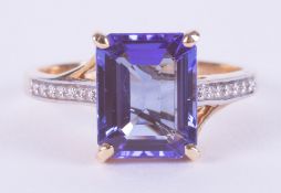 A 14ct yellow gold ring set with a central emerald cut Tanzanite, 3.10 carats, AA quality, with