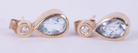 A pair of 9ct yellow gold earrings set with a pear shaped aquamarine with a small round brilliant