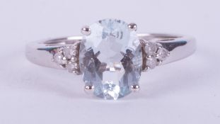 A 9ct white gold ring set with an oval cut Aquamarine, 1.60 carats set with a trefoil of diamonds to