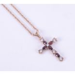 A 9ct yellow gold cross set with oval cut garnets interspaced with cubic zirconia's with a