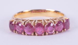 A high carat yellow gold (not tested or hallmarked) ring set with seven oval cut Burmese rubies,