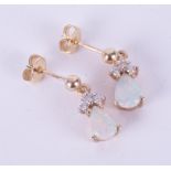 A pair of 9ct yellow gold drop earrings set with a pear shaped cabochon cut white opal and a