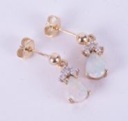 A pair of 9ct yellow gold drop earrings set with a pear shaped cabochon cut white opal and a