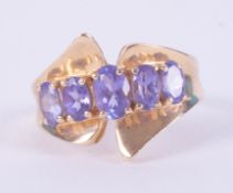 An unusual designed 14k yellow gold ring set with five oval cut tanzanite's, 4.17gm, size K 1/2.
