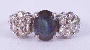 A white gold (no hallmarks & not tested) ring set with a central oval cut sapphire, approx. 1.40