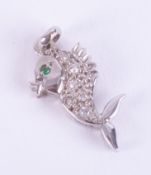 An 18ct white gold fish pendant set with a small round cut emerald and six little round cut