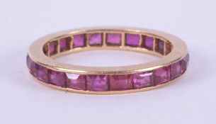 A yellow gold (no hallmarks & not tested) full eternity set with emerald cut rubies, 2.45gm, size