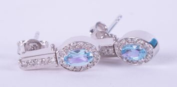 A pair of 14k white gold reversable earrings set with oval cut blue topaz, approx. total weight 0.46