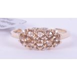 A 9ct yellow gold ring set with eight round cut champagne diamonds, total weight 0.56 carats
