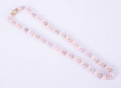 A string of freshwater pearls with peach, grey & pink lustre strung to an 18ct yellow gold brushed